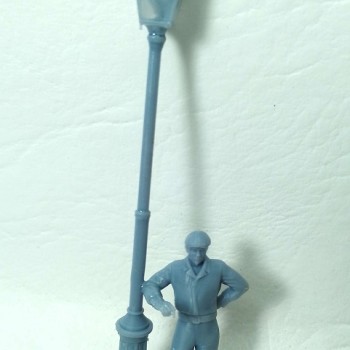 Farola con hombre apoyado con el codo.